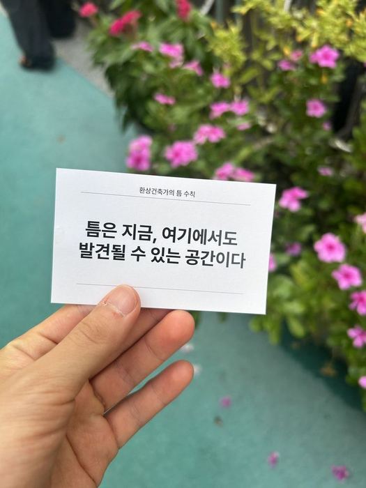 Manifesto card held beside flowers