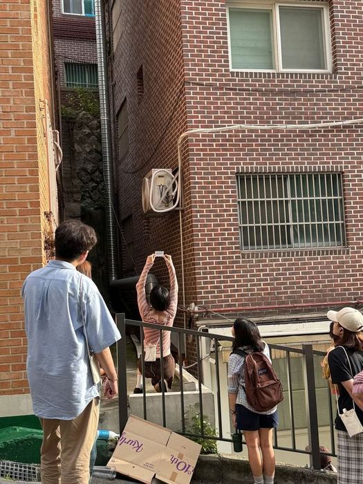 Audience observing a performer at an urban gap during Round 02